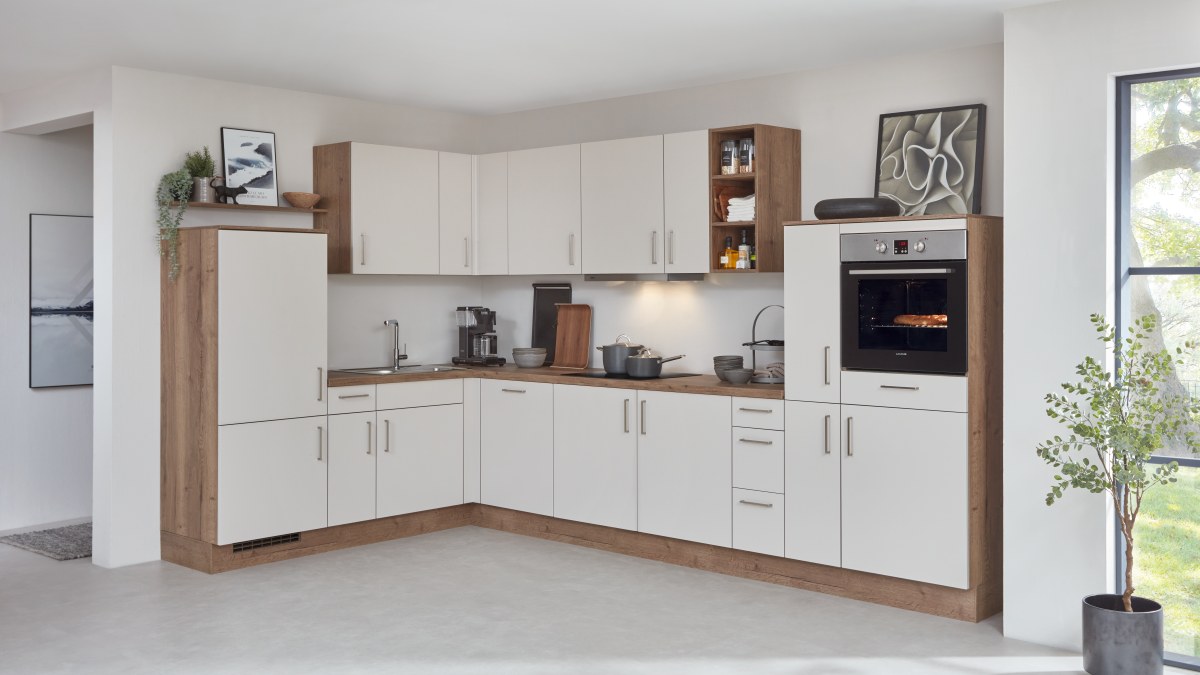 Weiße L-Küche mit Holzkorpus an Seitenwangen und Sockel, durchgehender Wandschrankzeile und eingebautem Backofen